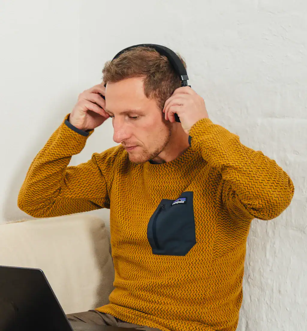 Iemand zet thuis een koptelefoon op, klaar om aan de ademsessie te beginnen.