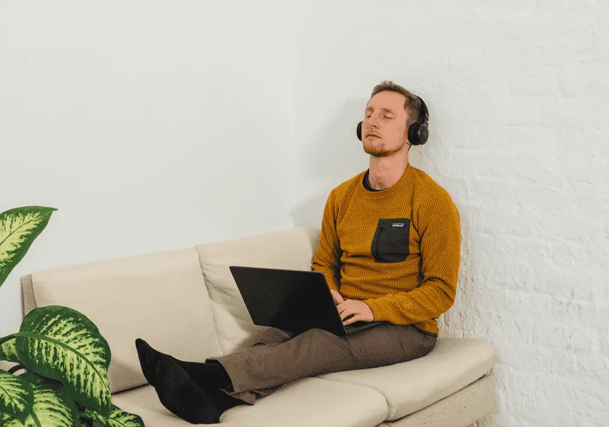 Jens Kemna doet thuis een begeleide online ademsessie met laptop en koptelefoon
